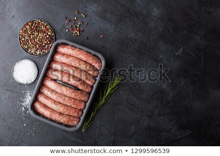 Stok fotoğraf: Raw Beef And Pork Sausage In Plastic Tray With Vintage Fork On Black Backgroundsalt And Pepper With