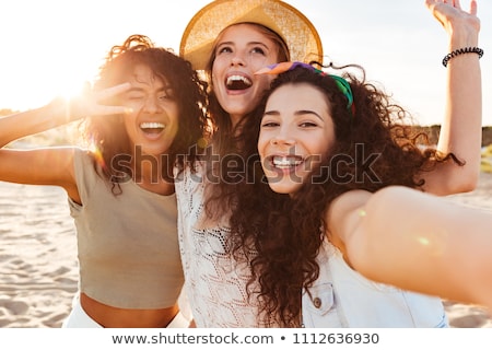 Foto d'archivio: Group Of Smiling Women Taking Selfie On Beach