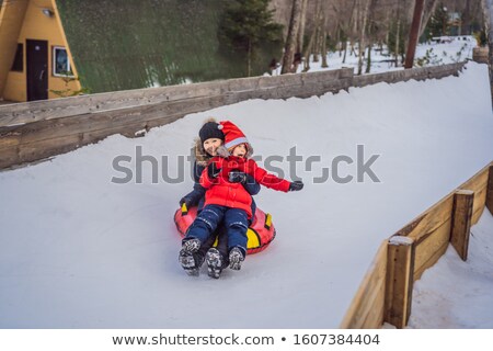 Foto stock: Mom Son Ride On An Inflatable Winter Sled Tubing Winter Fun For The Whole Family Banner Long Forma