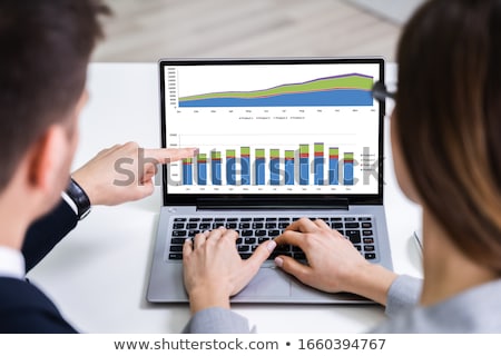 Foto stock: Businesspeople Analyzing Bar Graph On Computer