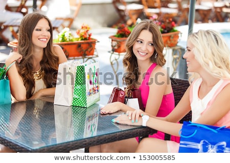 Foto stock: Woman With A Shopping Bag Drinking Tea Outside