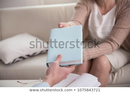 Stockfoto: Close Up Of A Female Hand Holding Pencil Above Textbook