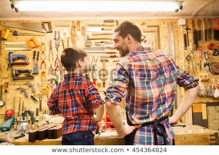 Stock fotó: Happy Father And Son With Wood Plank At Workshop