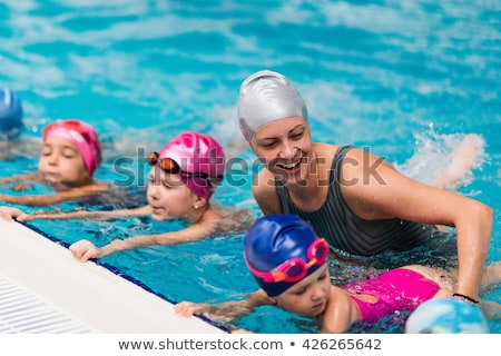 Zdjęcia stock: Woman Swimming Instructor For Children Is Teaching A Happy Boy To Swim In The Pool