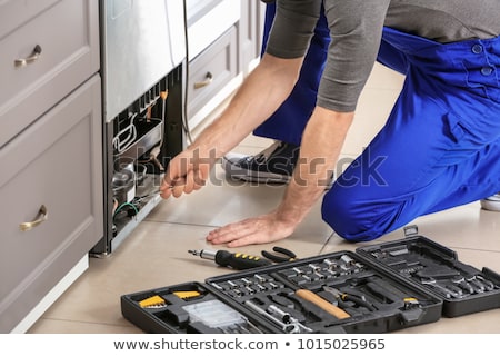 Stock foto: Technician Repairing Refrigerator In Kitchen