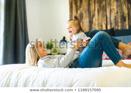 Foto stock: Mother And His Baby Daughter On Bed Having Fun