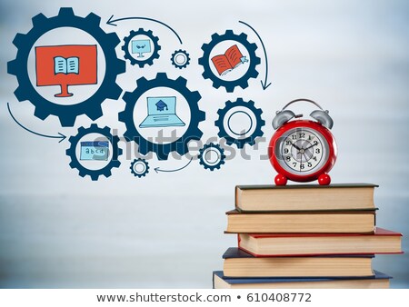 Stock photo: Pile Of Books And Clock With Blue Gear Graphics Against Blurry Grey Wood Panel