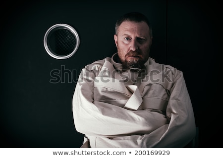 ストックフォト: Crazy Person In A Cell Wearing A Straitjacket