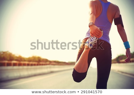 Foto d'archivio: Black Fit Runner Stretching For Warming Up Before Running