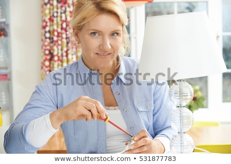 Stockfoto: Woman Wiring Electrical Plug On Lamp At Home