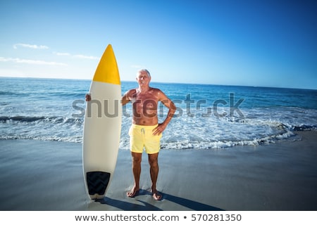 Stockfoto: Portrait Of Senior Man Standing By Surfboard