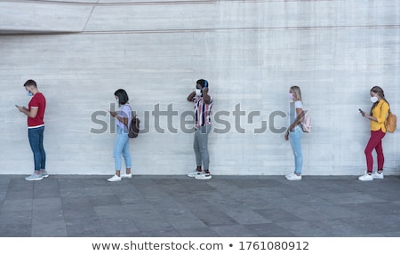 Grupo de jóvenes esperando en línea Foto stock © DisobeyArt