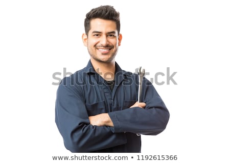 Foto stock: Mechanic Standing With Arms Crossed Holding Wrench