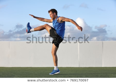Foto d'archivio: Male Runner Stretching For Warming Up Before Running