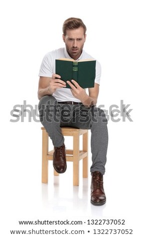 Stock fotó: Seated Man Is Shocked By The Book He Reads