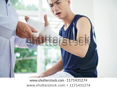 [[stock_photo]]: Unrecognizable Doctor Dressing Injured Hand Of Patient