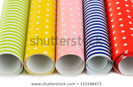 Foto stock: Rolls Of Multicolored Wrapping Paper With Red Bow For Gifts On G