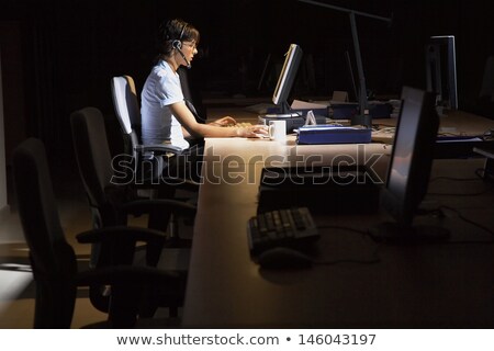 Stock photo: Hacker With Computer And Headset In Dark Room