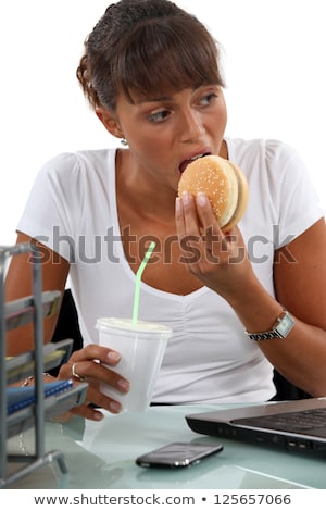 Stock foto: Hungry Female Executive Eating Hamburger