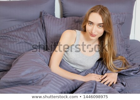 Foto d'archivio: A Woman Smiling Brightly As She Lies Awake In Bed