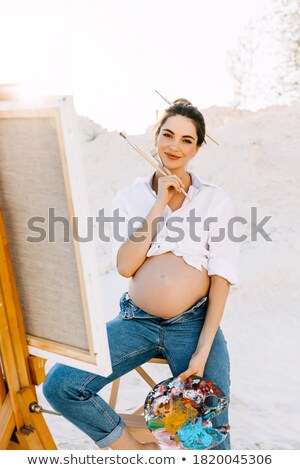 Stock photo: Pregnant Woman Sitting On Wooden Chair On The Beach