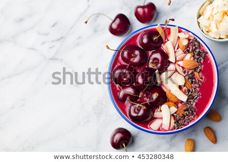 [[stock_photo]]: Smoothie Bowl With Fresh Black Cherries Coconut Flakes Almond And Cocoa Nibs Top View Copy Space