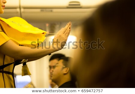 Stok fotoğraf: Hostess With Life Jacket On Airplane