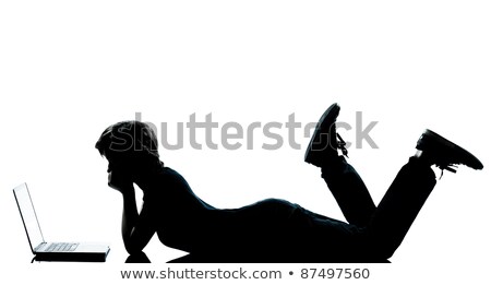 Stockfoto: Boy And Girl On A White Background Lie In Front Of A Laptop And