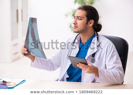Zdjęcia stock: Young Doctor Looking At X Ray Image In Mhealth Concept