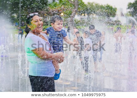 Stock foto: Happy Mom With Little Son Enjoying Water Fountains