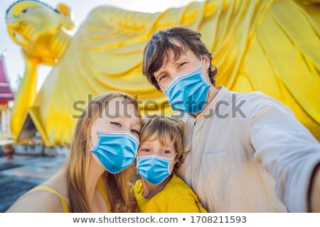 Foto stock: Happy Tourists Mother Father And Son On Background Oflying Buddha Statue