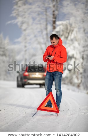Foto stock: Handsome Man Setting Up A Warning Triangle And Calling For Assistance