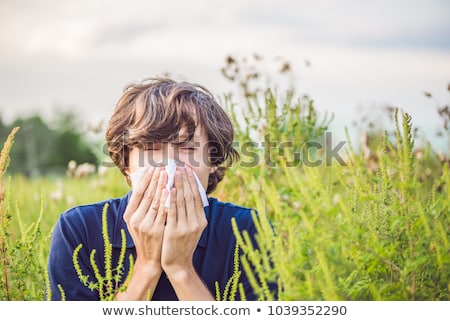 Foto stock: Young Man Sneezes Because Of An Allergy To Ragweed