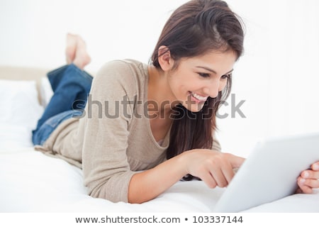 Foto stock: Happy Young Woman With Tablet Pc In Bed At Home