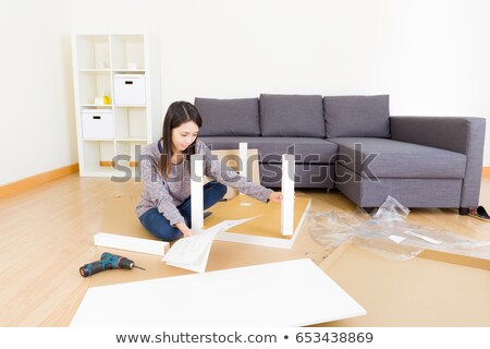 Сток-фото: Young Woman Is Assembling A Cupboard