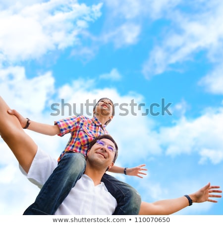 Foto stock: Boy Riding Piggy Back On His Fathers Back