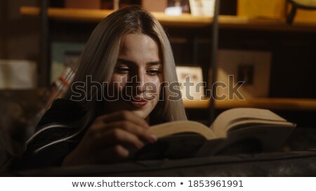 Foto stock: Blonde Girl Happily Relaxing In The Books