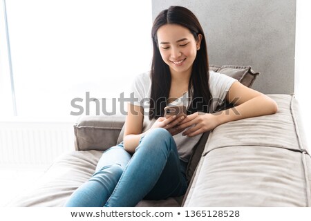 Foto stock: Gorgeous Young Women Chatting On A Sofa In A Living Room