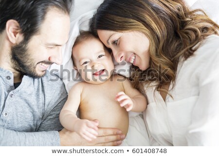 Stockfoto: Mother Father And Baby Child On A White Bed