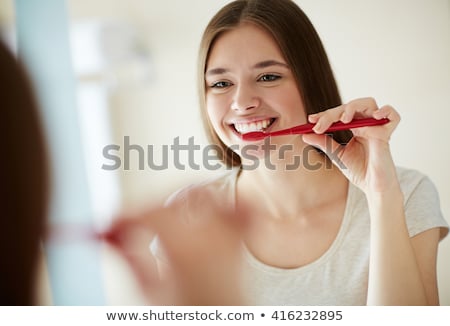 商業照片: Happy Young Beautiful Woman In Bathroom Brushing Her Teeth