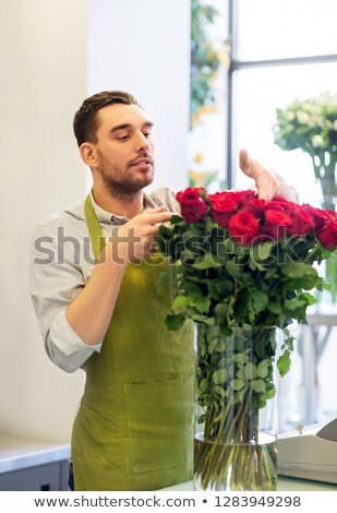 [[stock_photo]]: Florist Or Seller Setting Red Roses At Flower Shop