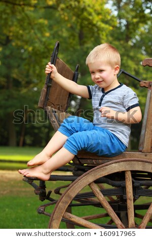 Stock photo: Old Fashioned Little Boy Sitting At A Vintage Wooden Carriage