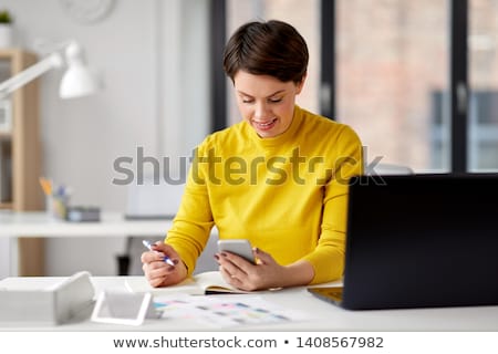 Stok fotoğraf: Smiling Ui Designer Using Smartphone At Office