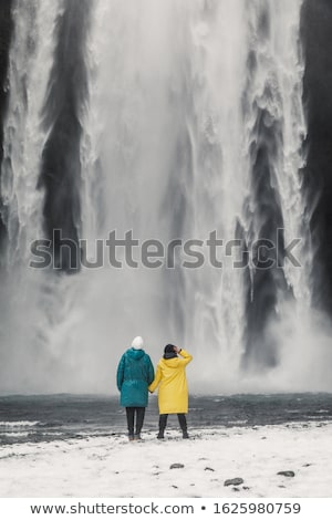 Stok fotoğraf: Tourist Near Skogafoss Waterfall In Iceland