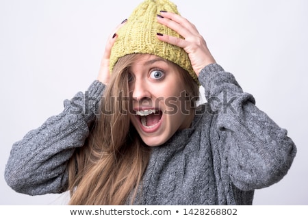 [[stock_photo]]: Young Woman In Warm Clothing And Looking Shocked