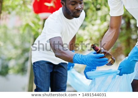 Foto stock: Volunteers With Garbage Bags Cleaning Park Area