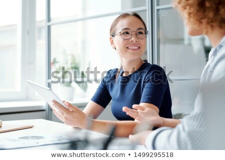 ストックフォト: Young Smiling Analyst With Touchpad Looking At Colleague While Listening To Her