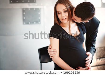 Stockfoto: Man Kissing His Pregnant Wife On The Neck