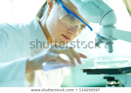 Foto d'archivio: Beautiful Female Biotechnology Scientist Chemist Working In Lab