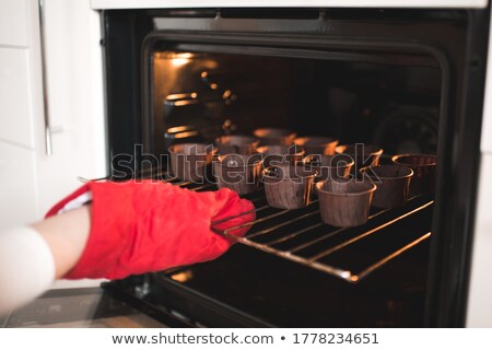 Foto d'archivio: Pastry Baker Putting Pies Or Cakes In Oven